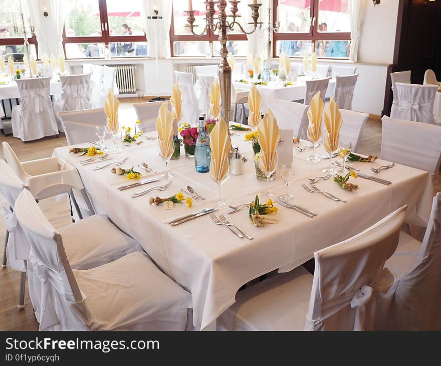 A table setting for party with white tablecloths. A table setting for party with white tablecloths.