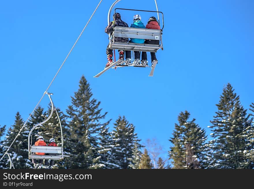 Skiers on a ski lift in a skiing resort.