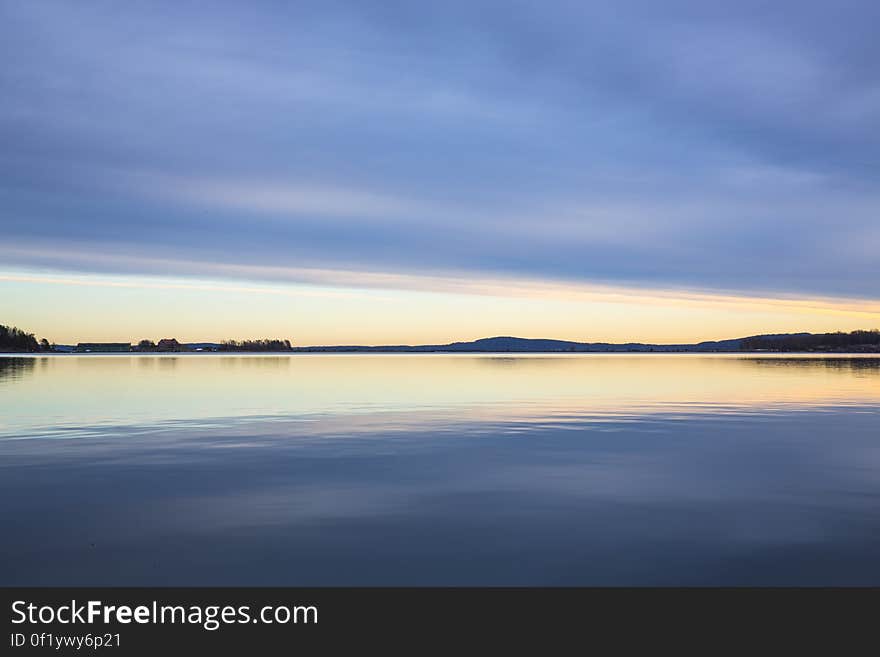 A calm lake reflecting the sunset skies above. A calm lake reflecting the sunset skies above.