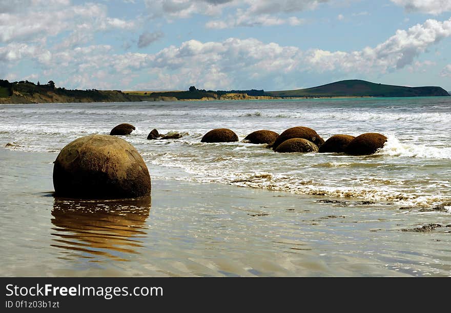 The Moeraki Boulders are geological marvels, exposed by erosion of sedimentary rocks laid down from 65 to 13 million years ago. They are formed by the gradual precipitation of calcite in mudstone over 4 million years. These spherical concretions are internationally significant for their scientific value and are a popular tourist attraction. The Moeraki Boulders are geological marvels, exposed by erosion of sedimentary rocks laid down from 65 to 13 million years ago. They are formed by the gradual precipitation of calcite in mudstone over 4 million years. These spherical concretions are internationally significant for their scientific value and are a popular tourist attraction.