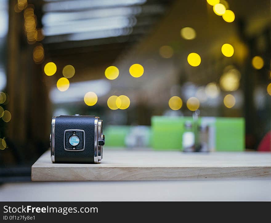 An old film camera on table with defocused background.