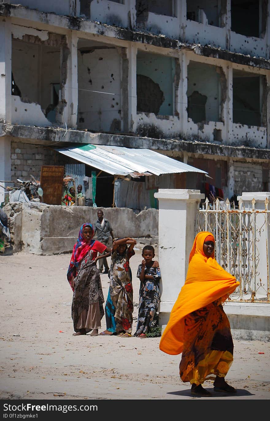 A woman walks past Somali children standing in front of a derelict building in the Abdul-Aziz district of the Somali capital Mogadishu 09 November 2012. The United Nations Security Council on November 7 renewed the mandate of the African Union Mission in Somalia &#x28;AMISOM&#x29; peacekeeping force for a further four months to continue providing support to the Government of Somalia in its efforts to bring peace and stability to the Horn of African country. AU-UN IST PHOTO / STUART PRICE. A woman walks past Somali children standing in front of a derelict building in the Abdul-Aziz district of the Somali capital Mogadishu 09 November 2012. The United Nations Security Council on November 7 renewed the mandate of the African Union Mission in Somalia &#x28;AMISOM&#x29; peacekeeping force for a further four months to continue providing support to the Government of Somalia in its efforts to bring peace and stability to the Horn of African country. AU-UN IST PHOTO / STUART PRICE.