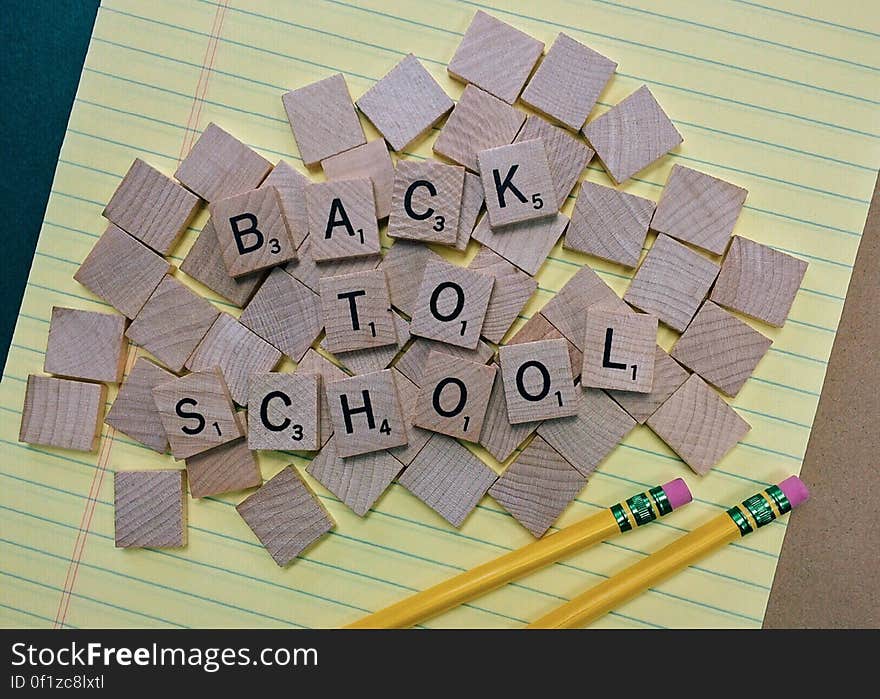 A piece of paper and pencils with letter blocks forming the sentence "back to school".