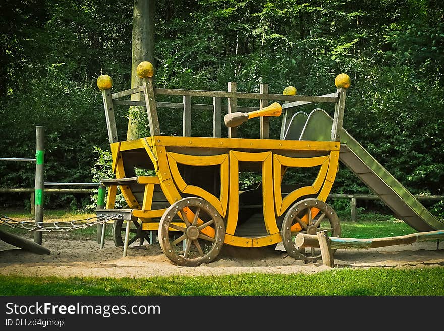 A children's play house shaped like a wagon in on a playground. A children's play house shaped like a wagon in on a playground.