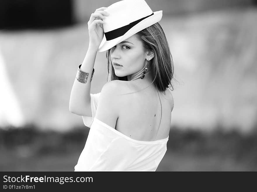 A woman in white dress and a trilby hat in black and white. A woman in white dress and a trilby hat in black and white.