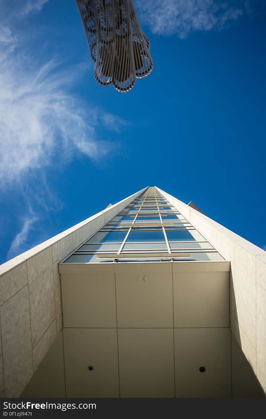 A low angle view of a high rise building against the blue sky. A low angle view of a high rise building against the blue sky.