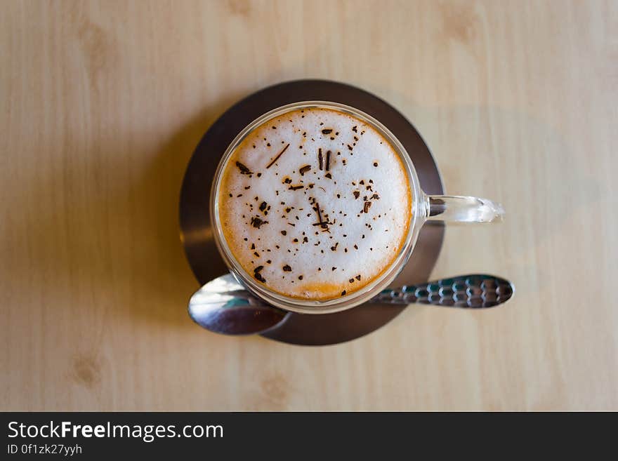 A cup of coffee with milk foam and cocoa powder on top.