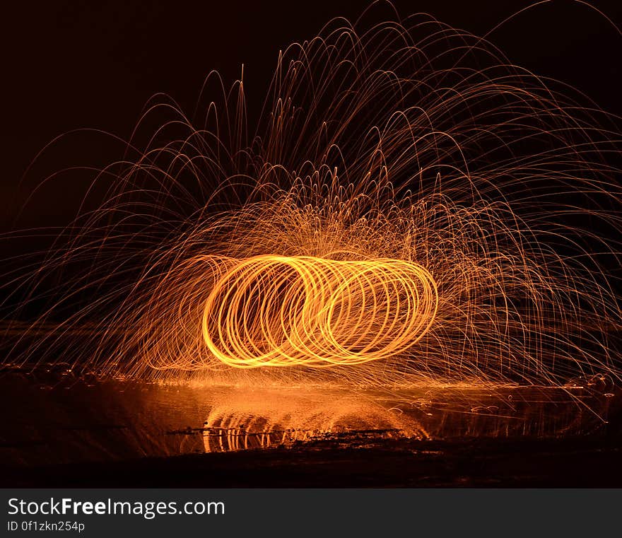 Lon exposure of a fire performance in the night with person spinning a burning object leaving trails.