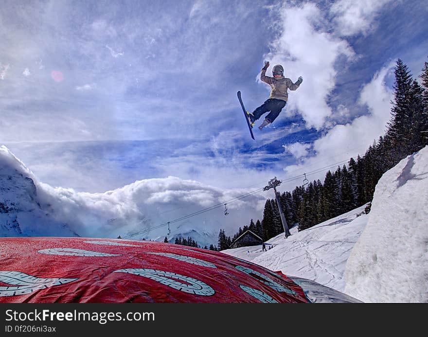 Ski jumper on alpine slopes against blue skies