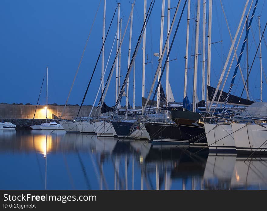 A harbor at night with boats docked in. A harbor at night with boats docked in.