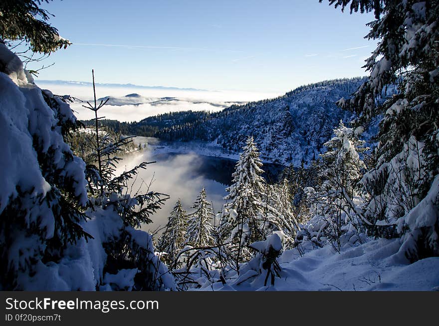 A small lake in the middle of snowy mountains or hills. A small lake in the middle of snowy mountains or hills.