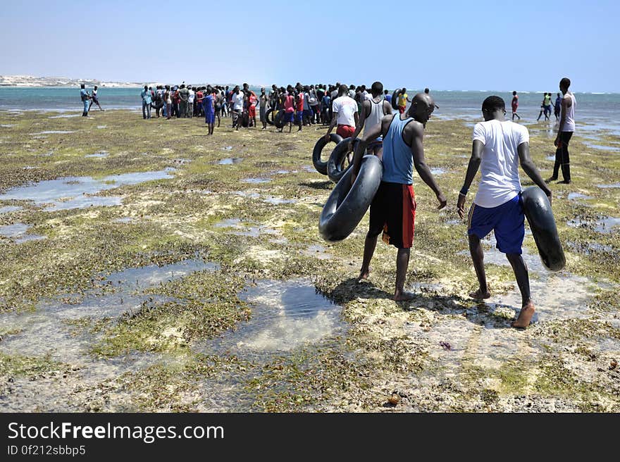 Young men carry old inner tubes they&#x27;ve used to get to a sandbank off of Lido beach in the Somali capital of Mogadishu on January 31. The Mogadishu lifeguards, consisting entirely of a volunteer force of fisherman, began patrolling Lido beach in September 2013 after a spate of drownings. Mogadishu&#x27;s beaches have become a popular destination for the city&#x27;s residents since al Shabab withdrew the majority of its militants from the city in 2011. AU UN IST PHOTO / Tobin Jones. Young men carry old inner tubes they&#x27;ve used to get to a sandbank off of Lido beach in the Somali capital of Mogadishu on January 31. The Mogadishu lifeguards, consisting entirely of a volunteer force of fisherman, began patrolling Lido beach in September 2013 after a spate of drownings. Mogadishu&#x27;s beaches have become a popular destination for the city&#x27;s residents since al Shabab withdrew the majority of its militants from the city in 2011. AU UN IST PHOTO / Tobin Jones