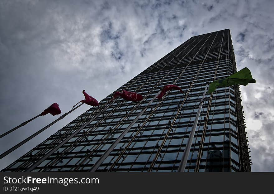 A tall office building with flags in front.