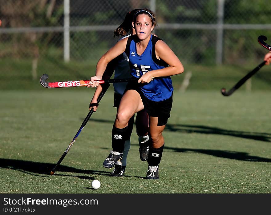 Woman Wearing Blue and Black Jersey Holding Field Hockey