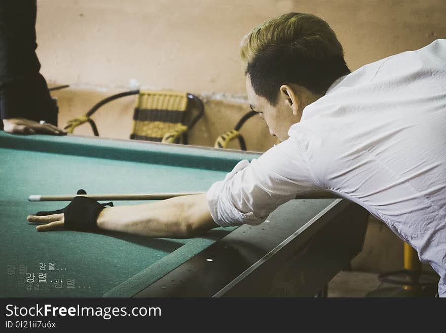 A man plans a shot in a pool game. A man plans a shot in a pool game.