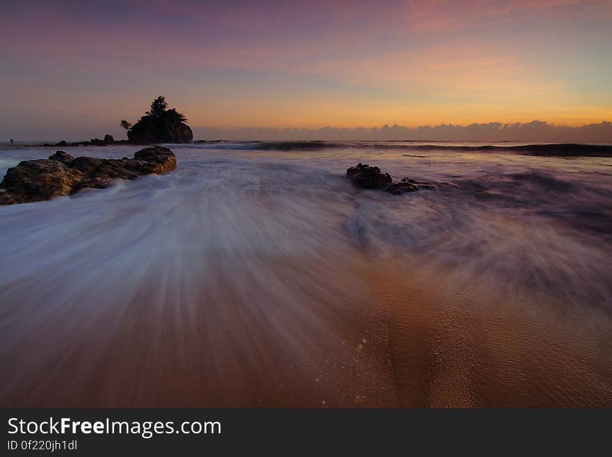 A seascape long exposure with setting sun in the horizon. A seascape long exposure with setting sun in the horizon.