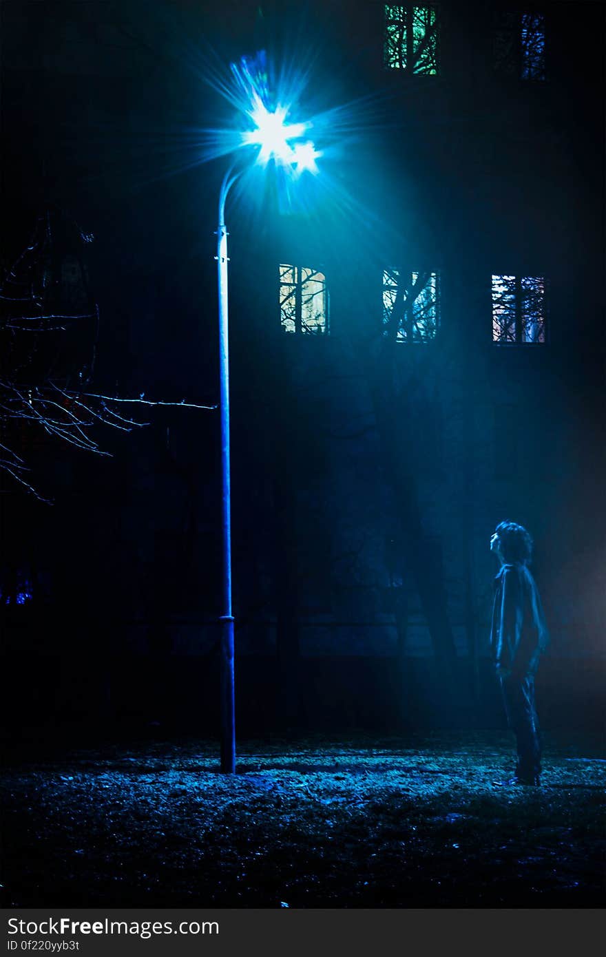 Man Standing in Front of Street Light Turned on