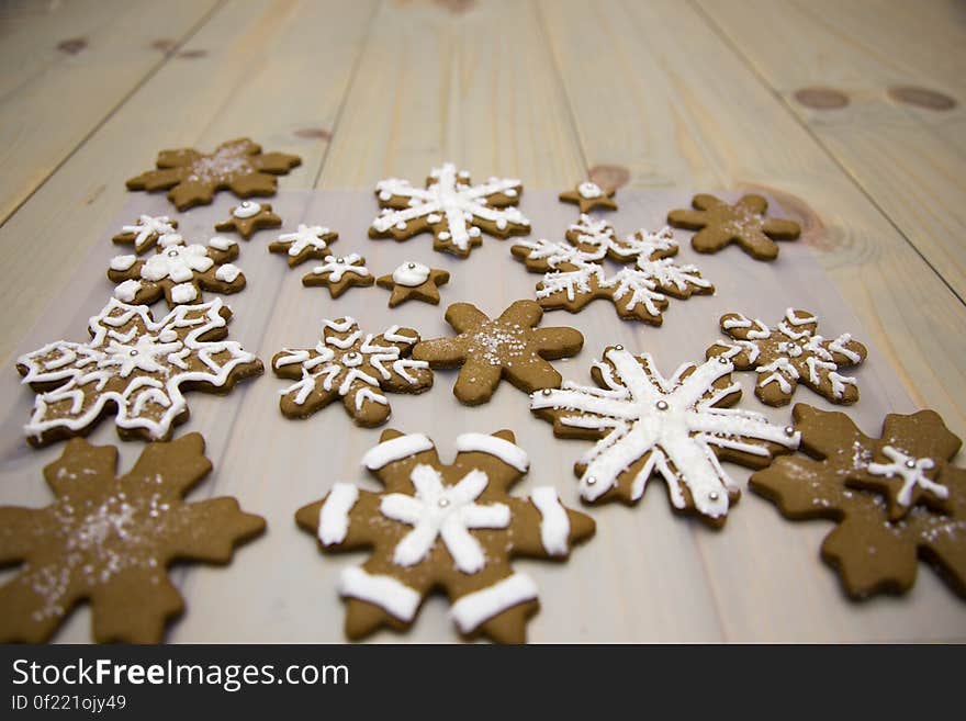 Gingerbread snowflake cookies on a wooden background.