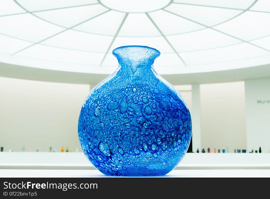 A close up of a blue glass vase indoor. A close up of a blue glass vase indoor.