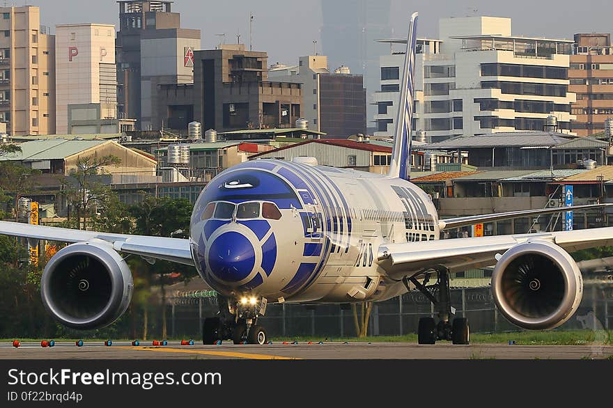 Commercial airliner on runway outside modern urban airport.