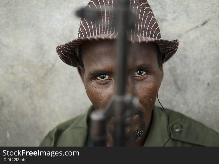 A member of Ras Kambani, a local militia allied with the Kenya Defense Forces in Kismayo city, sits guard over a meeting at the seaport. The meeting was attended by members of the local business community who met with foreign journalists at the seaport to discuss the recent liberation of the city by al-Shabab and the future of the region&#x27;s charcoal industry. AU-UN IST PHOTO / TOBIN JONES. A member of Ras Kambani, a local militia allied with the Kenya Defense Forces in Kismayo city, sits guard over a meeting at the seaport. The meeting was attended by members of the local business community who met with foreign journalists at the seaport to discuss the recent liberation of the city by al-Shabab and the future of the region&#x27;s charcoal industry. AU-UN IST PHOTO / TOBIN JONES.