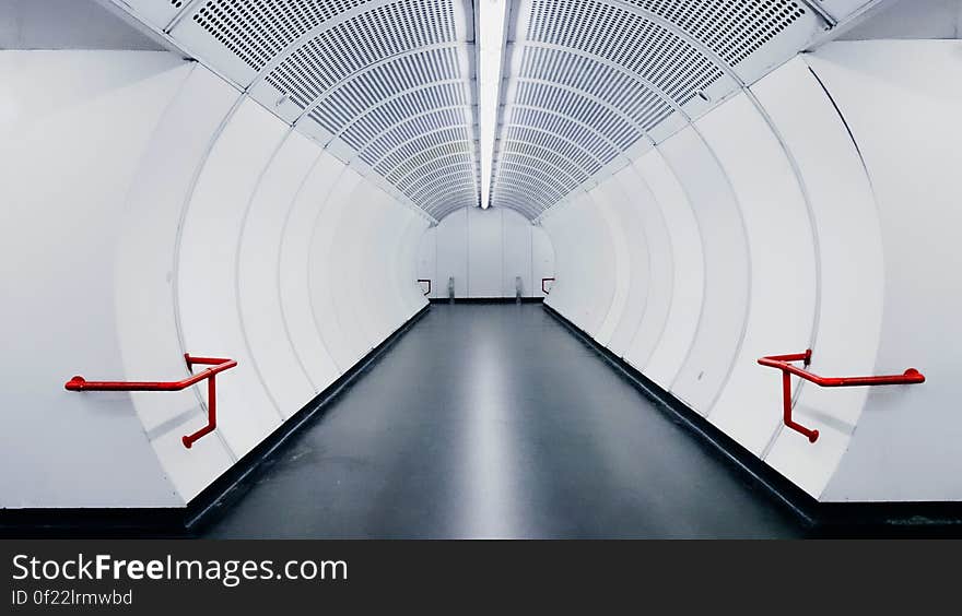 Empty modern white subway tunnel with strip lighting.
