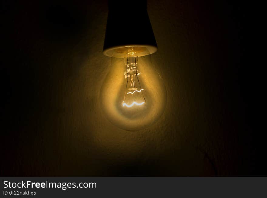 A dim incandescent light bulb. A dim incandescent light bulb.