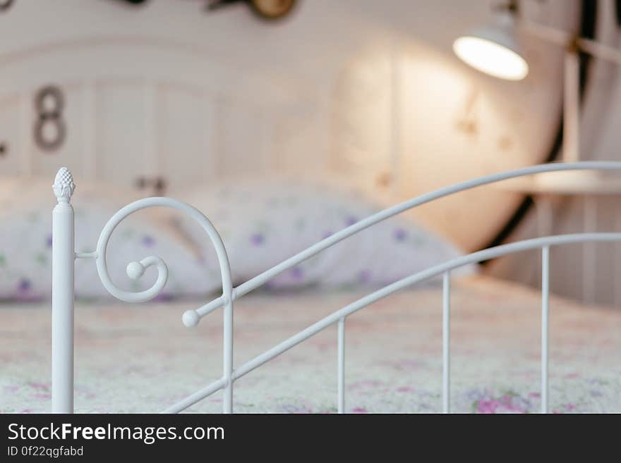 A close up of a bed in the bedroom with white metal frame. A close up of a bed in the bedroom with white metal frame.