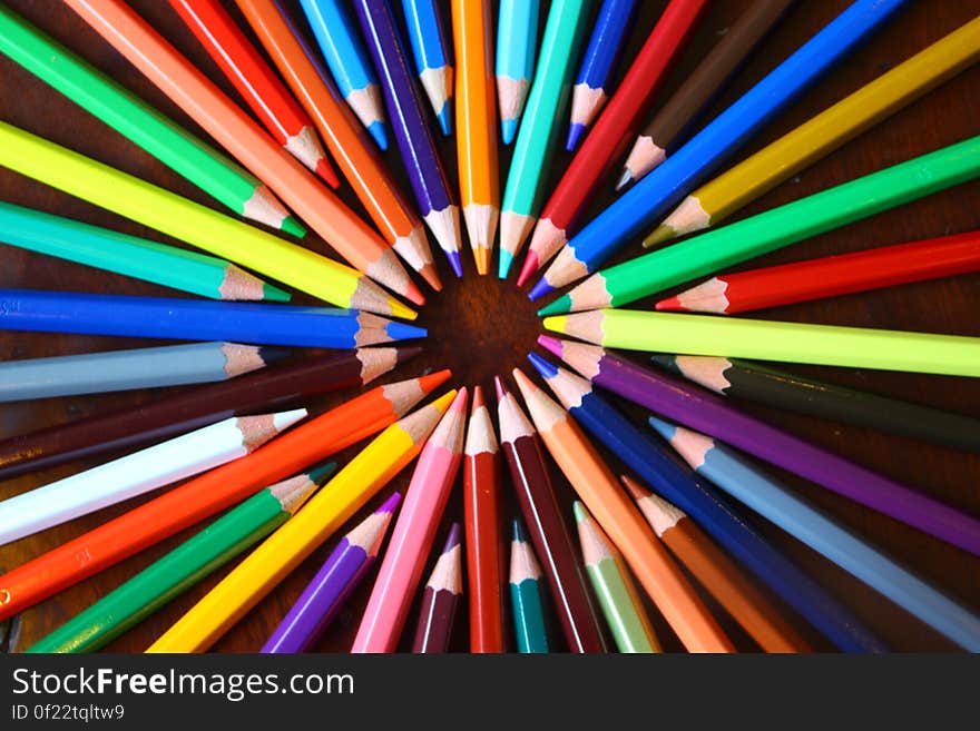 Colorful pencils in circle pointing at each others.