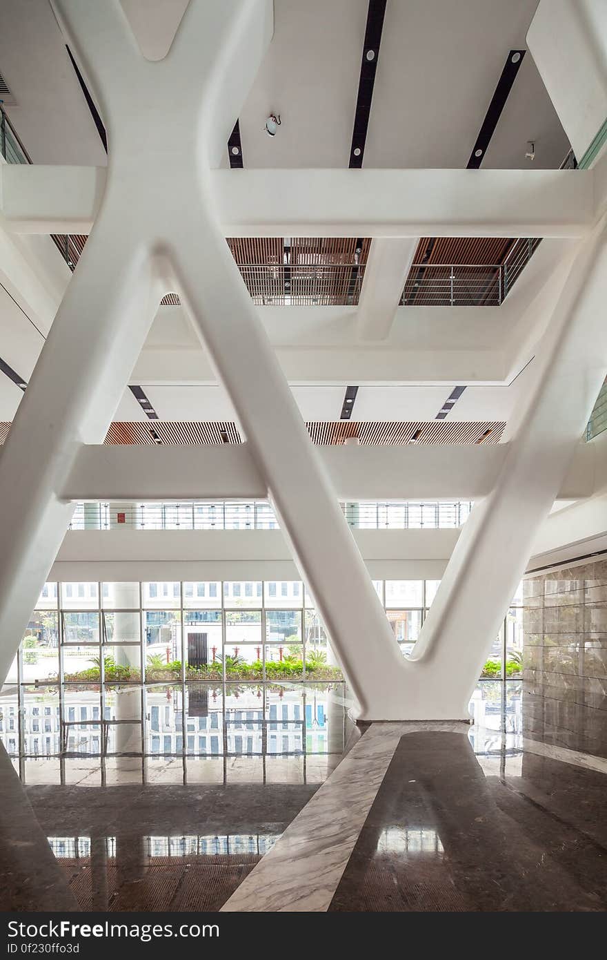 Large hall in modern building with white ceiling supports and reflection.