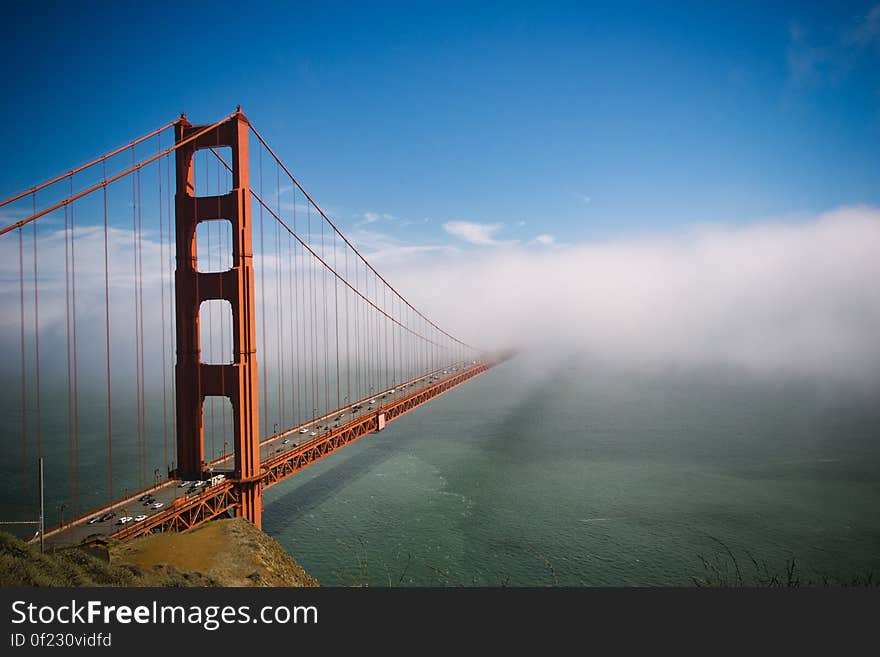 View of the Golden Gate Bridge in San Francisco, California, with a low fog obscuring the far side of the span.