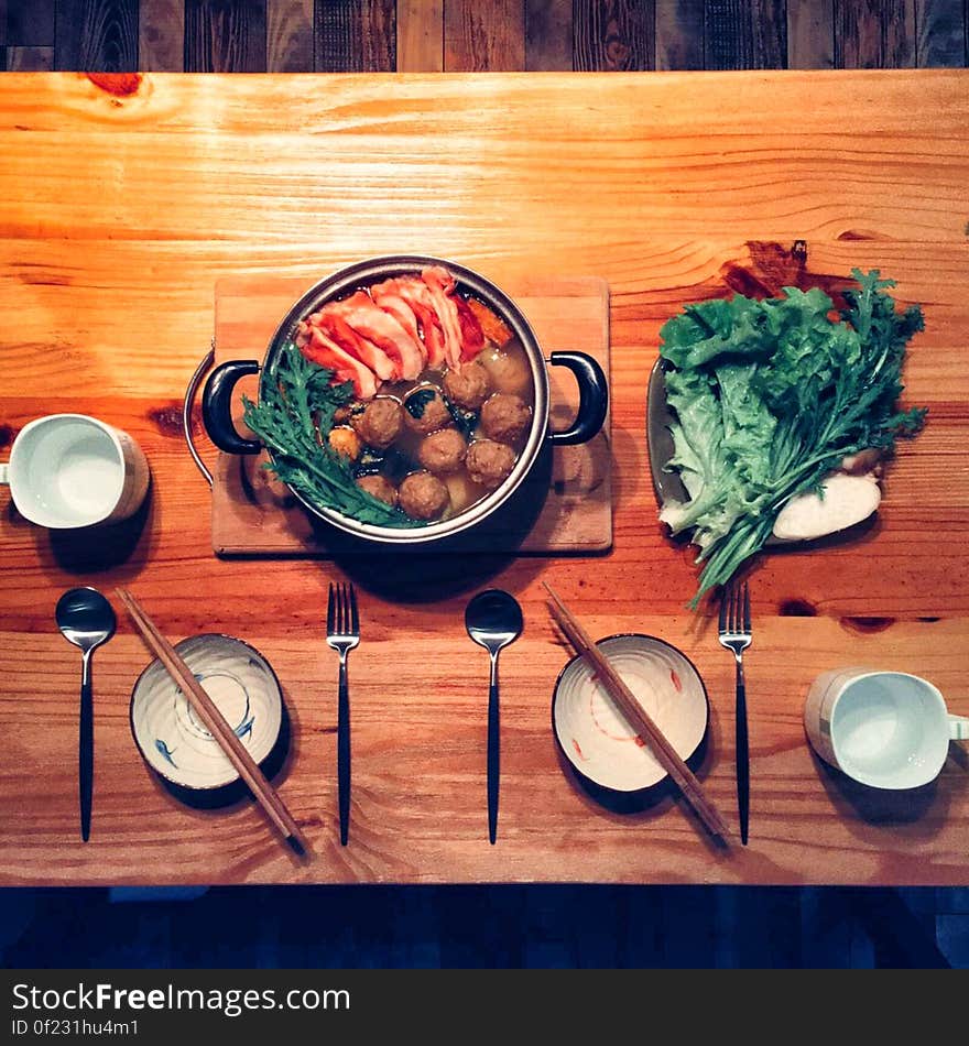 Overhead view of traditional Chinese food on wooden table with place settings, bowls and chopsticks. Overhead view of traditional Chinese food on wooden table with place settings, bowls and chopsticks.