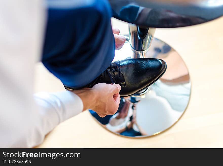 A man tying his shoelaces. A man tying his shoelaces.