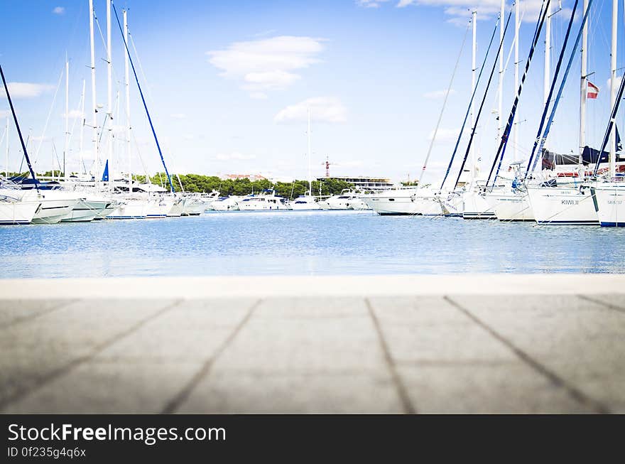 A view across a harbor with yachts and sailboats moored at the dock. A view across a harbor with yachts and sailboats moored at the dock.