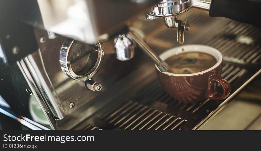 A coffee shop machine with a cup of espresso being prepared. A coffee shop machine with a cup of espresso being prepared.