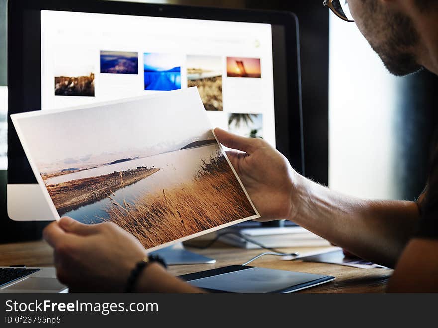 A photographer or graphics designer looking at printed photographs. A photographer or graphics designer looking at printed photographs.