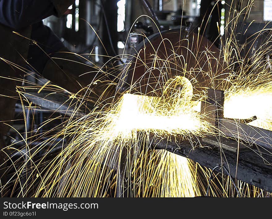 A workshop with hot metal sparks flying from machine process. A workshop with hot metal sparks flying from machine process.