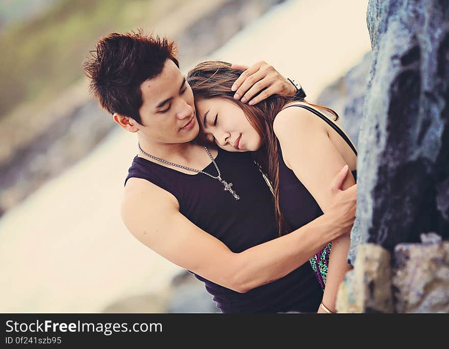 Man Hugging a Woman Wearing Black Tank Top