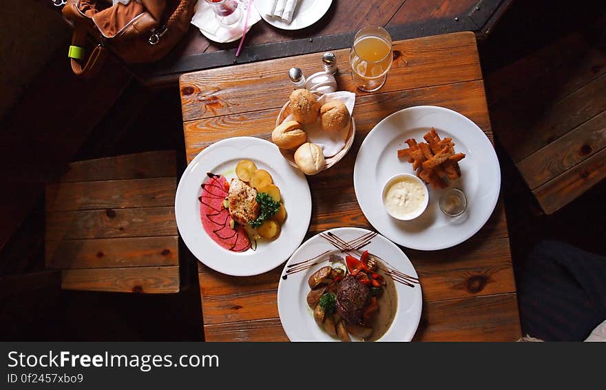 A table set with three plates of various dishes. A table set with three plates of various dishes.