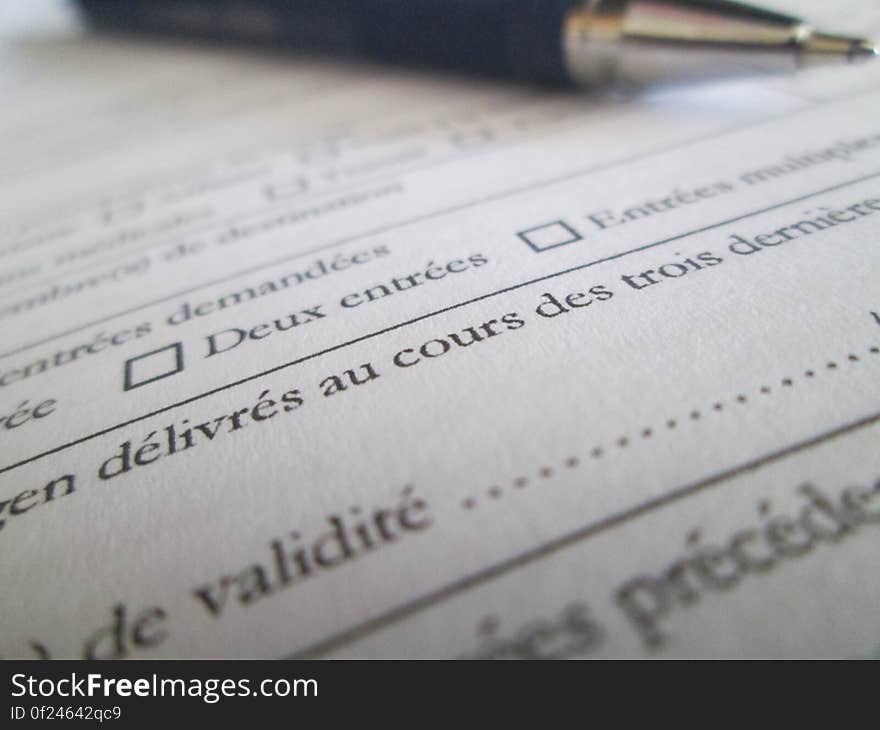 A close up of a formal document in French and a pen on it. A close up of a formal document in French and a pen on it.