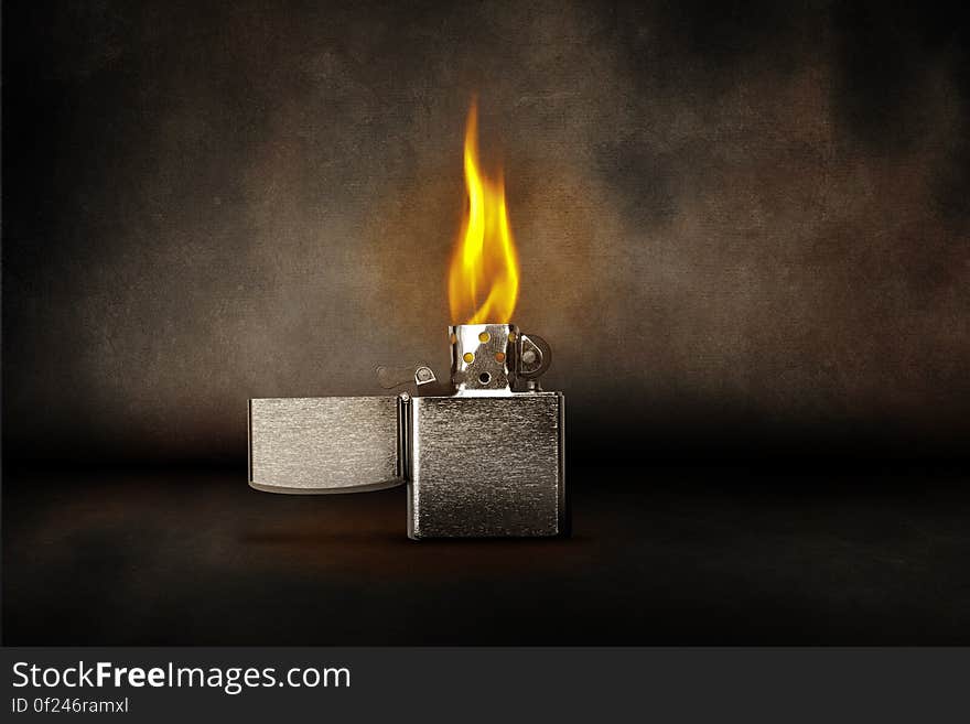 A burning zippo lighter and smoke around.