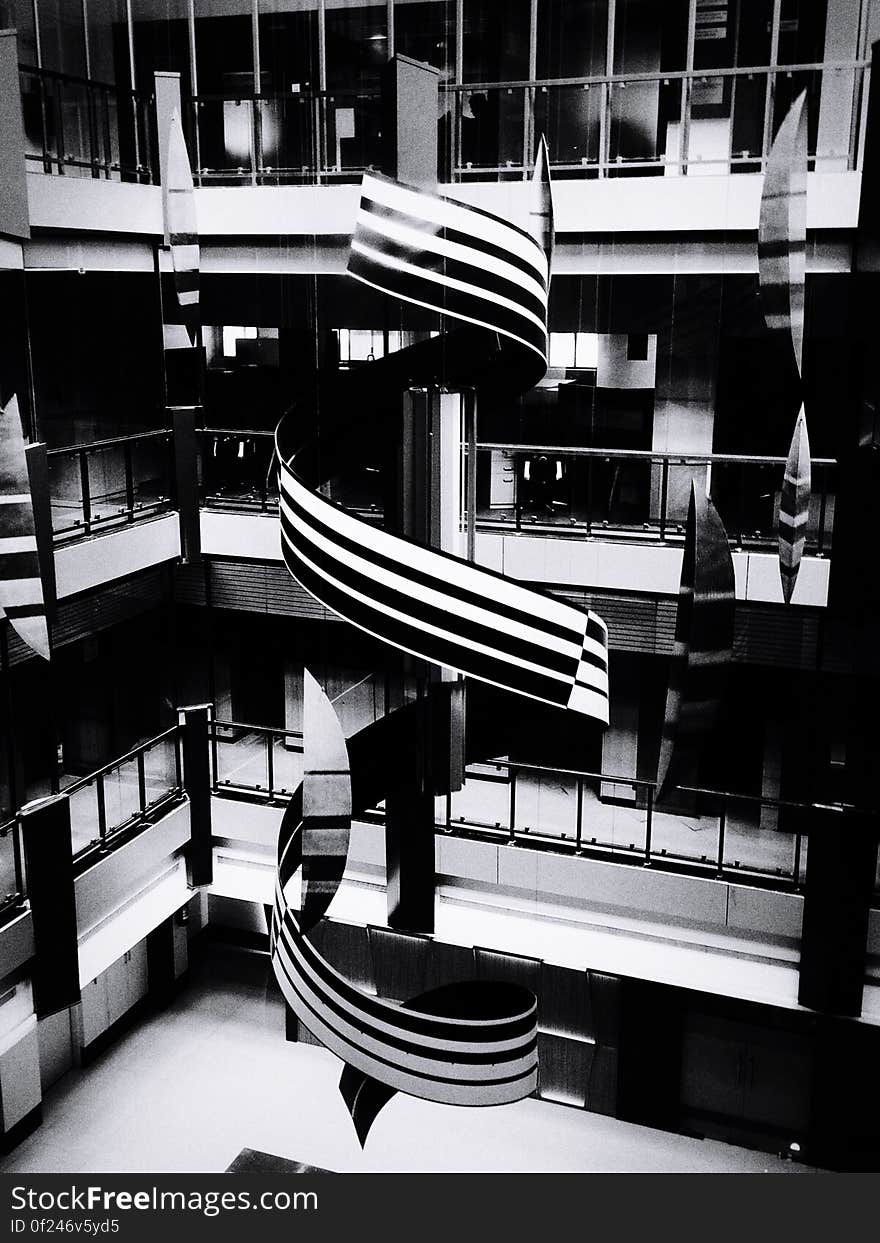 A black and white photo of a spiral structure inside a building. A black and white photo of a spiral structure inside a building.