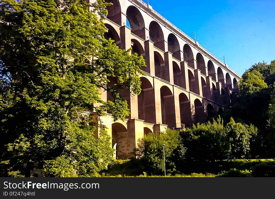 A building with arched openings and greenery around.