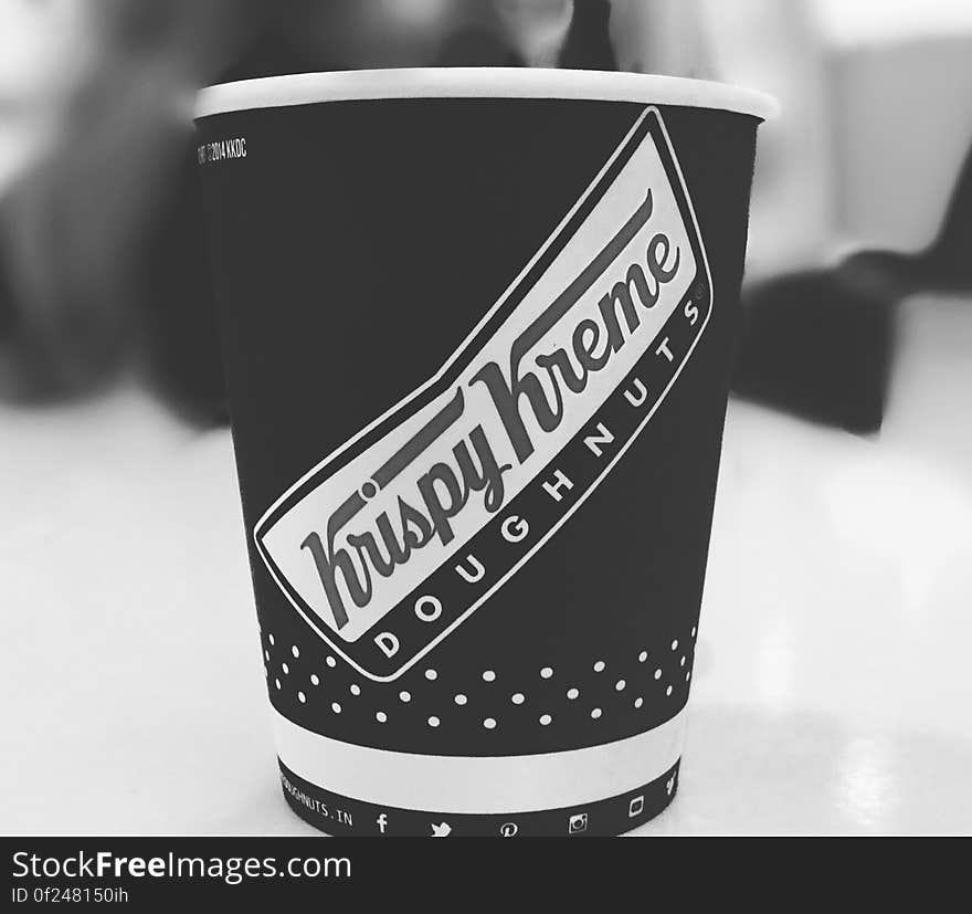 Black and white side view of Krispy Kreme Doughnuts cup of coffee.