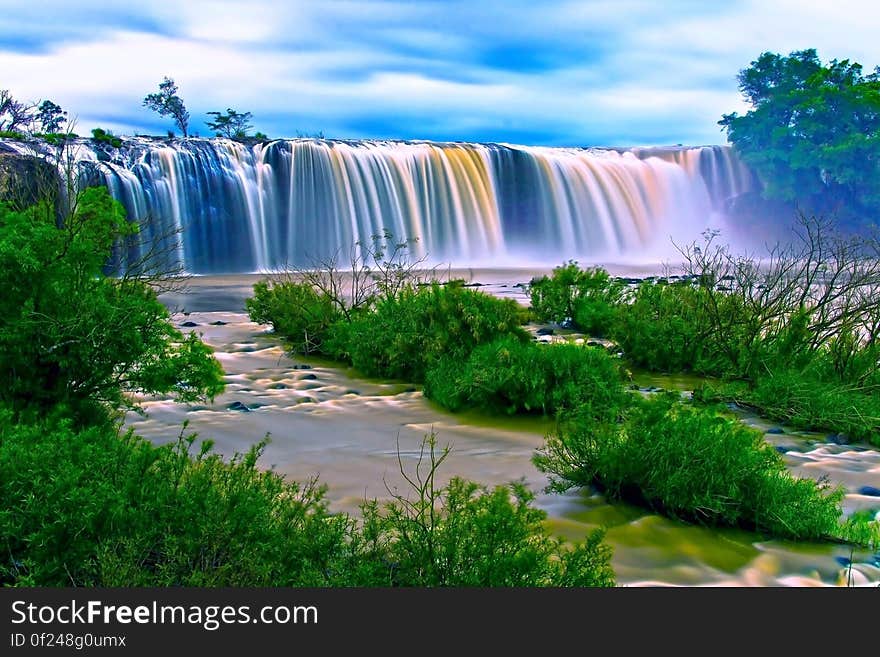 Water Falls Surrounding Green Grass during Daytime