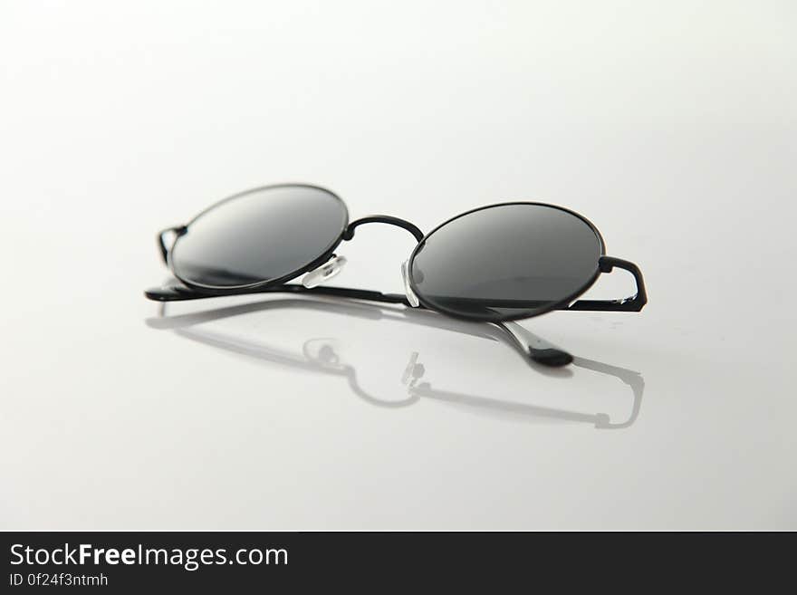 Black Frame Sunglasses on White Surface