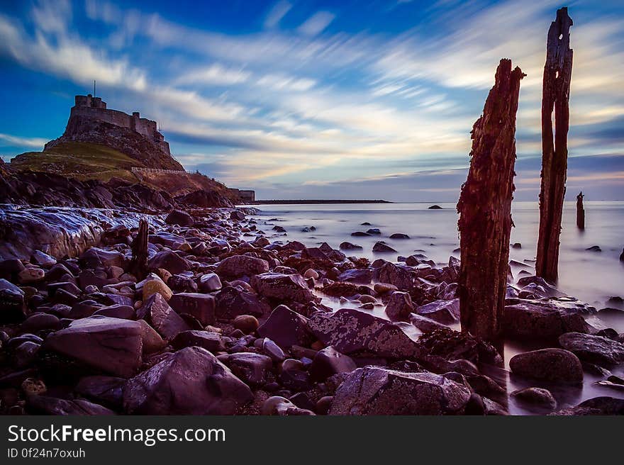 Rock beach and a castle on the hill at the shore. Rock beach and a castle on the hill at the shore.