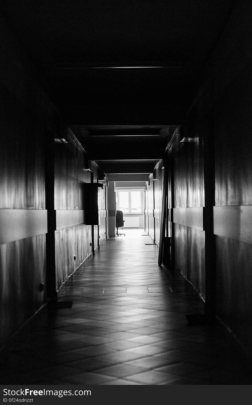 Black and white view looking down long empty hallway. Black and white view looking down long empty hallway.