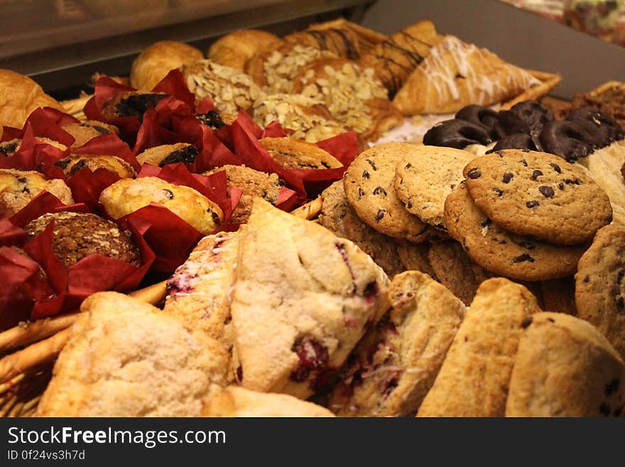 A close up of a bakery shelf with baskets full of baked goods.