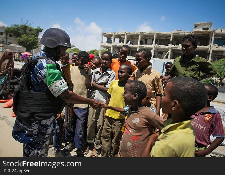 A Ugandan police officer serving as part of a Formed Police Unit &#x28;FPU&#x29; with the African Union Mission in Somalia &#x28;AMISOM&#x29; shakes hands with a group of Somali children during a foot patrol in the Kaa&#x27;ran district of the Somali capital Mogadishu 09 November 2012. AMISOM&#x27;s FPUs are working with their counterparts in the Somali Police Force &#x28;SPF&#x29; in helping to provide security in Mogadishu in addition to training and mentoring the SPF on policing techniques and practises. AU-UN IST PHOTO / STUART PRICE. A Ugandan police officer serving as part of a Formed Police Unit &#x28;FPU&#x29; with the African Union Mission in Somalia &#x28;AMISOM&#x29; shakes hands with a group of Somali children during a foot patrol in the Kaa&#x27;ran district of the Somali capital Mogadishu 09 November 2012. AMISOM&#x27;s FPUs are working with their counterparts in the Somali Police Force &#x28;SPF&#x29; in helping to provide security in Mogadishu in addition to training and mentoring the SPF on policing techniques and practises. AU-UN IST PHOTO / STUART PRICE.